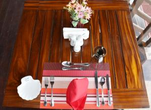 a table with utensils on top of a wooden table at Nilaveli Beach Resort - Level 1 Certified in Nilaveli