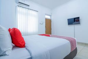 En eller flere senge i et værelse på SUPER OYO 1755 De'balcon Accomodation Near Ngurah Rai Airport