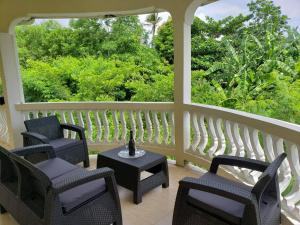 ChoiseulComfort Suites Three Bedroom Apartment的门廊配有椅子和桌子,设有窗户