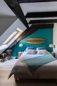- une chambre avec un lit et une planche de surf sur le mur dans l'établissement Gîte de l'Ange, à Colmar