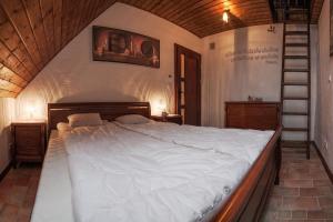 a bedroom with a large white bed and a staircase at Apartament Villa Toscana in Jaworki