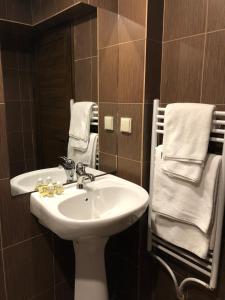 bagno con lavandino, specchio e asciugamani di Hotel Panorama Velingrad a Velingrad