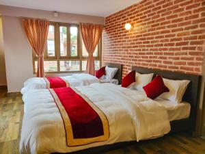 two beds in a room with a brick wall at Hotel Central Bhaktapur in Bhaktapur