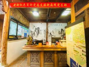 a restaurant with a counter with a sign on the wall at Old Street Courtyard (Free Pick up Service) in Huangshan