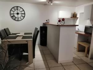 a dining room with a table and a clock on the wall at Ty bily in Plaudren