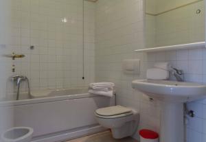 y baño con aseo, bañera y lavamanos. en STUDIO ROMA 41 - Affitti Brevi Italia, en Lecco