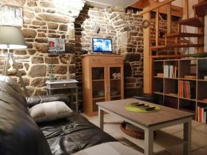 ein Wohnzimmer mit einem Tisch und einer Steinmauer in der Unterkunft Ty bily in Plaudren
