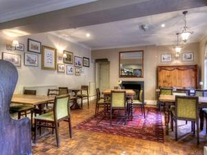 a dining room with tables and chairs and a fireplace at The Talbot in Iwerne Minster