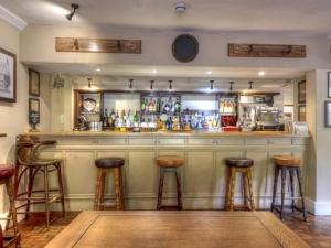 un bar con taburetes en una habitación en The Talbot, en Iwerne Minster