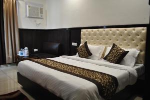 a bedroom with a large bed with a large headboard at Hotel Green Valley in Katra