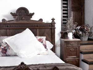 a bedroom with a bed with a wooden headboard at Can Marc in Sant Esteve de Palautordera