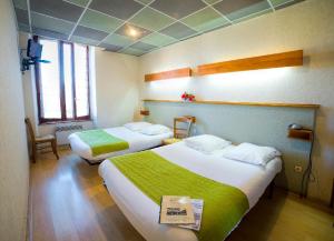 Cette chambre comprend 2 lits avec des draps verts et blancs. dans l'établissement Hotel de la Gare, à Sévérac-le-Château