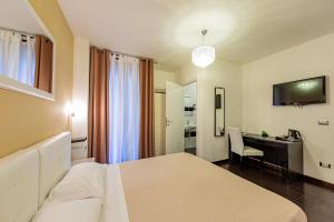 アルゲーロにあるSweetdreams Plaça Civicaのベッドとデスクが備わるホテルルームです。