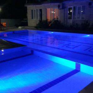 a swimming pool with blue lights in a house at Dolphin Yunus Hotel in Pamukkale