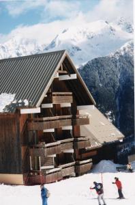 two people are standing in front of a ski lodge at La résidence du Pleynet aux 7 Laux in La Ferrière