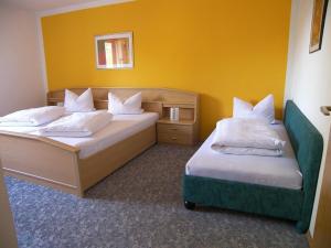 2 Betten in einem Zimmer mit gelben Wänden in der Unterkunft Ferienhaus Sonja in Lindberg