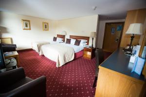 ein Hotelzimmer mit zwei Betten und einem Schreibtisch in der Unterkunft Whitewater Hotel & Spa in Newby Bridge