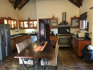 cocina con mesa de madera y nevera en Bushvilla Umoja Kruger, en Phalaborwa