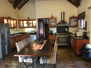 a kitchen with a wooden table and a refrigerator at Bushvilla Umoja Kruger in Phalaborwa