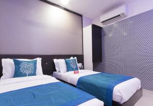a bedroom with two beds with blue and white sheets at Hotel Golden Sagar in Mumbai