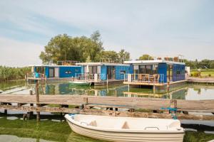 a row of houses on a dock with a boat on the water at Hafenresort Karnin in Karnin