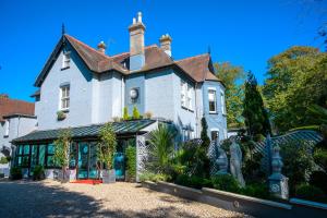 uma grande casa branca com um telhado em Derby Manor em Bournemouth