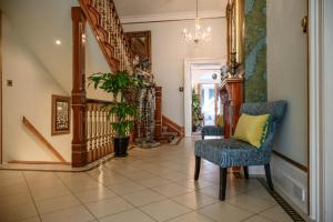 a hallway with a blue chair and a yellow pillow at Derby Manor in Bournemouth