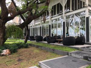 Ban Bo Khaem的住宿－班圖塔雷藍篤公寓，前面有一堆椅子的建筑