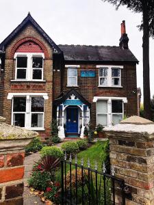 una casa de ladrillo con una puerta azul y una valla en Caspian Hotel en Londres