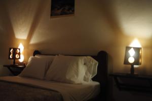 a bedroom with a bed with two lights on it at Casa do vermelho in Povoação