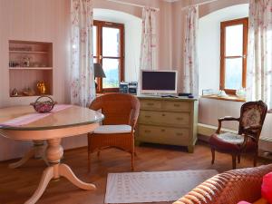ein Wohnzimmer mit einem Tisch und einem TV in der Unterkunft Almbauernhof in Ruhpolding