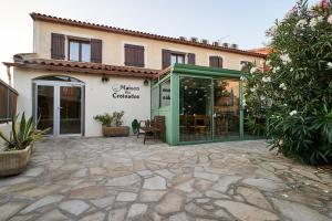 - un bâtiment avec une porte verte et une terrasse dans l'établissement Maison des Croisades, à Aigues-Mortes
