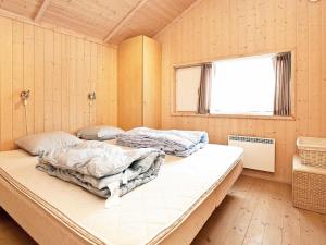 two beds in a room with a window at Three-Bedroom Holiday home in Rødby 6 in Kramnitse