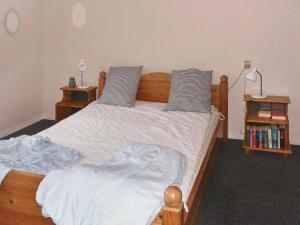 a bedroom with a large wooden bed with two pillows at 4 person holiday home in Broager in Broager