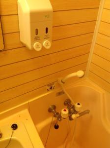un bagno con servizi igienici e un dispenser di sapone sul muro di Royal Hotel a Nagasaki