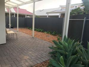 a patio with a fence and a chair in a yard at Gawler Townhouse U1 1 Bedroom in Gawler +4 photos