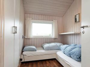 a small room with a bed and a window at 10 person holiday home in V ggerl se in Marielyst