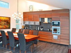 uma cozinha com uma mesa de jantar em madeira e cadeiras em Four-Bedroom Holiday home in Inndyr 2 em Inndyr