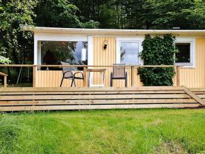 een huis met een terras met twee stoelen en een tafel bij Holiday home in Tyringe in Tyringe