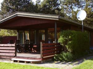 un porche cubierto de una casa con mesa y sillas en 6 person holiday home in Pr st en Togeholt