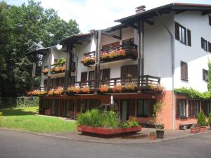 Un grand bâtiment blanc avec des fleurs sur les balcons dans l'établissement Auf dem roten Fels, à Eppenbrunn