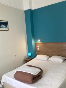 a bedroom with a large white bed with a blue wall at Hotel Kastoria in Thessaloniki