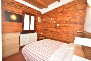 - une chambre avec un lit dans une pièce dotée de murs en bois dans l'établissement Rifugio Le Chevalier, à Roccaraso