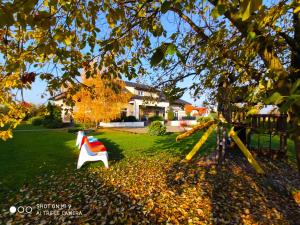 a white and red bench in a yard with a house at Hotel Graffit in Świebodzin
