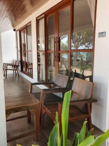 a porch with two chairs and a table and windows at The C Samet Beach Resort SHA Plus in Ko Samed