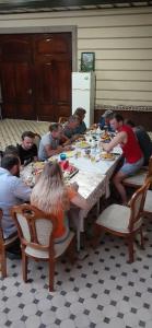 een groep mensen die rond een tafel eten bij B&B Giza Registan in Samarkand