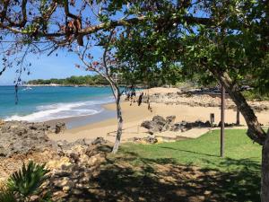 a beach with people walking on the sand at Comfortable Apartment in Caribbean Paradise in Sosúa