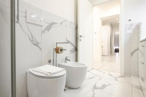 Baño blanco con aseo y lavamanos en Dimora Santo Stefano: Ampia, con Giardino privato, en Bolonia
