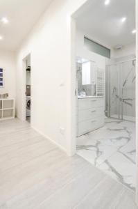 a white kitchen with marble floors and white walls at Dimora Santo Stefano: Ampia, con Giardino privato in Bologna