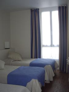 Ліжко або ліжка в номері Hotel Le Havre Bleu